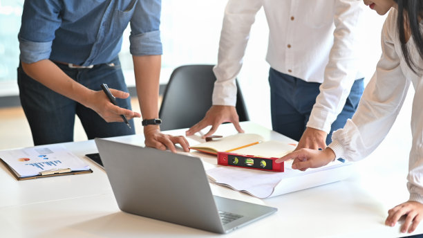 特写建筑师团队的规划蓝图在笔记本电脑和桌子上的蓝图。图片下载