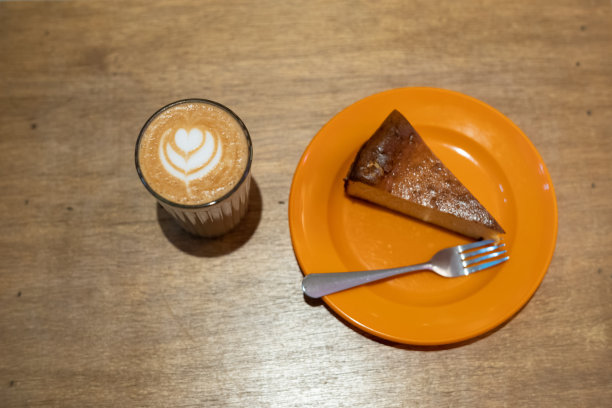 木桌上放着美味的白咖啡和芝士蛋糕图片下载