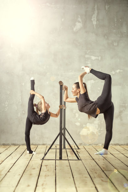 优雅的芭蕾舞小女孩站在舞蹈室和老师的手伸展图片下载