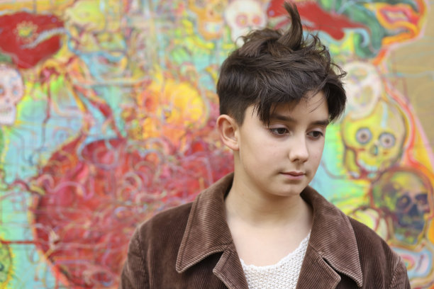 一个十几岁的男孩和一幅油画在画布上作画图片下载