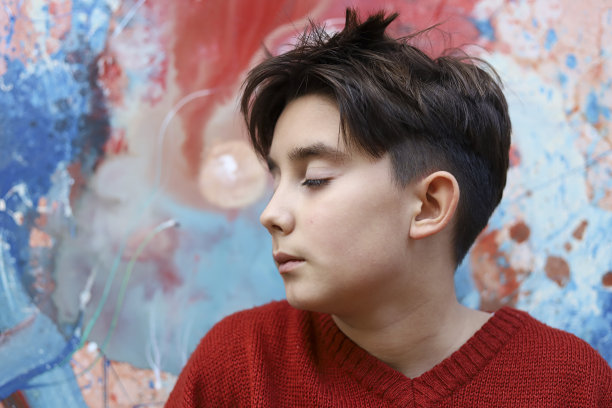 一个十几岁的男孩和一幅油画在画布上作画图片下载