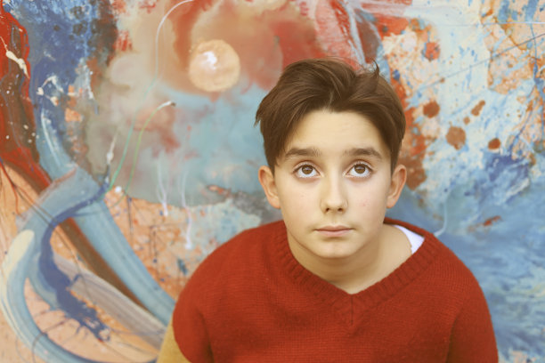 一个十几岁的男孩和一幅油画在画布上作画图片下载