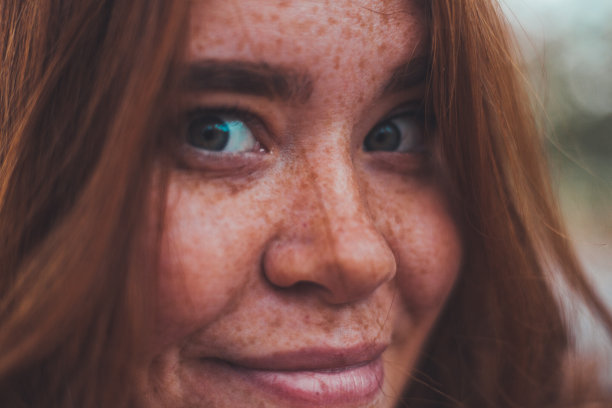 一个年轻的姜黄色女人的肖像在公园里，戴着帽子和围巾在秋天图片下载