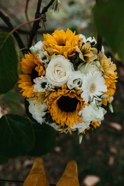 近距离的照片婚礼花束的向日葵和玫瑰。图片下载