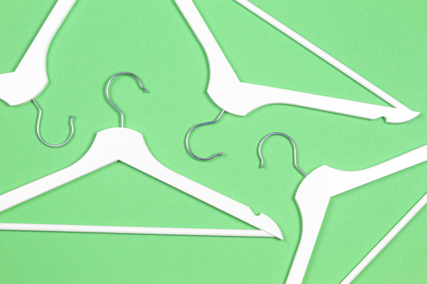 白色的木制衣架在淡绿色的背景上。购物，促销，社交媒体，新季概念图片下载