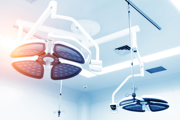 手术灯背景下的外科医生。图片下载