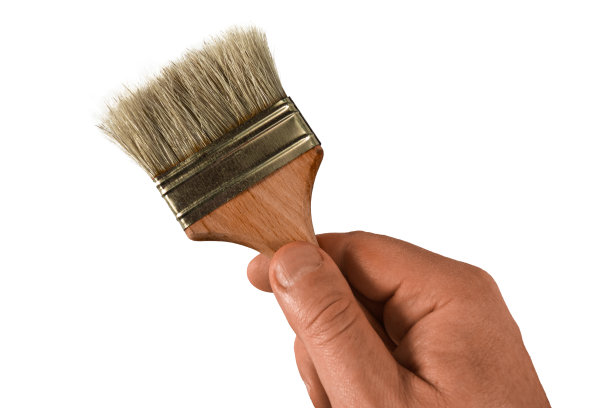 男人手里拿着一把刷子。孤立的特写白色背景。绘画装饰、家装或装修的概念。画笔作为染色的工作工具图片下载