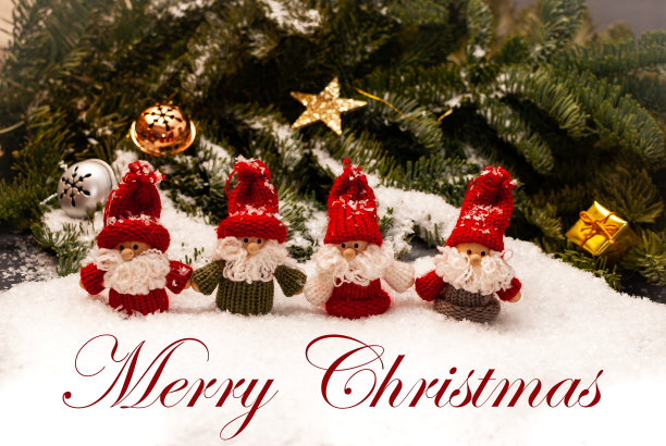 圣诞小矮人站在雪地上，身后的绿树枝上挂着圣诞装饰品，前面写着“圣诞快乐”图片下载