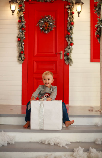 小男孩带着礼物在家里的院子里装饰圣诞节图片下载