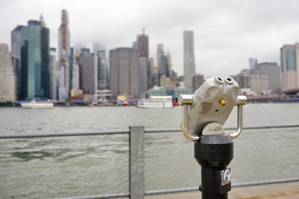 在雨天，用双筒望远镜眺望东河上空的曼哈顿天际线。图片下载