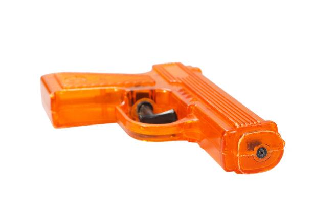 橙色塑料水枪，白色背景图片下载