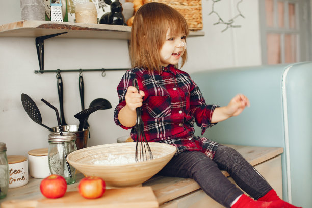 可爱的小女孩坐在厨房里图片下载