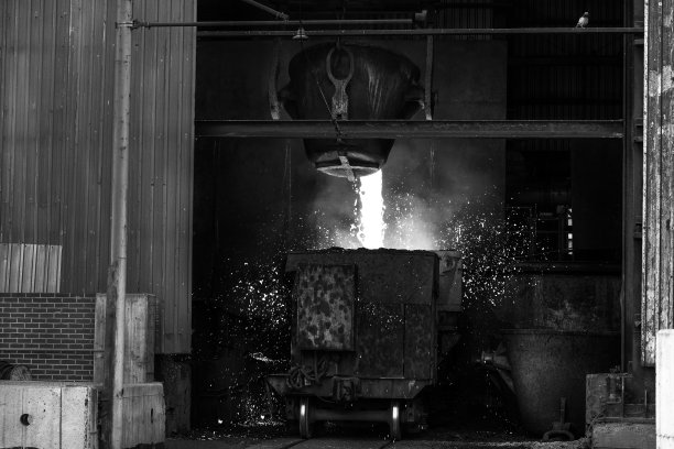 在工业铸造厂，熔化的金属正在倾倒到马车的熔炉里。铸造金属的制造依靠熔炉技术，因为金属通常在很高的温度下熔化。图片下载