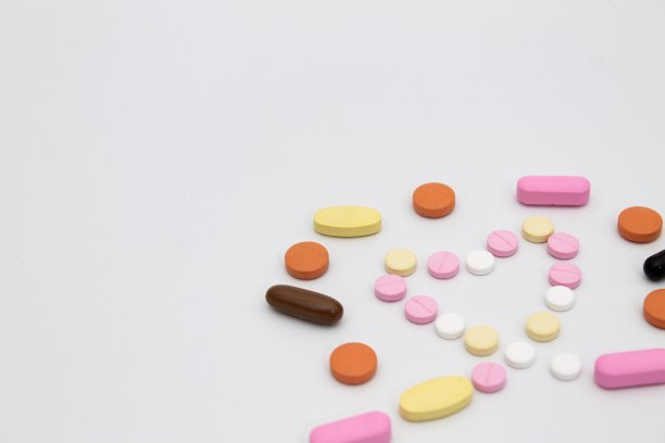 彩色和各种类型的药丸形成心脏符号在白色的背景图片下载