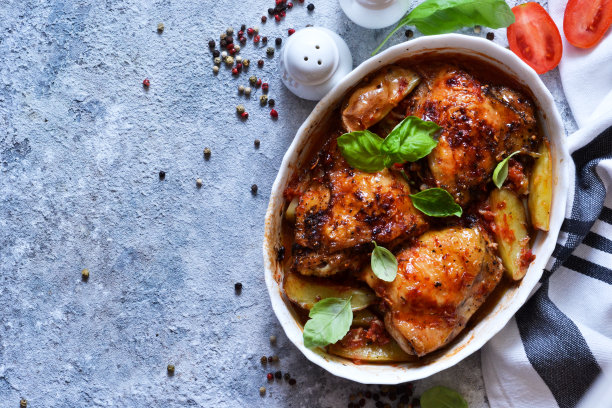 烤鸡腿配土豆、番茄酱和罗勒，背景是混凝土。从以上观点。图片下载