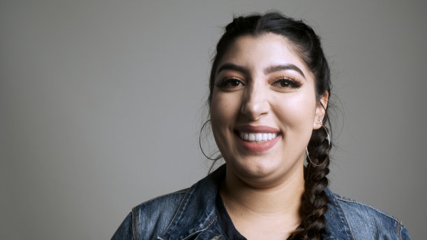 美丽微笑的年轻女子看着镜头图片下载