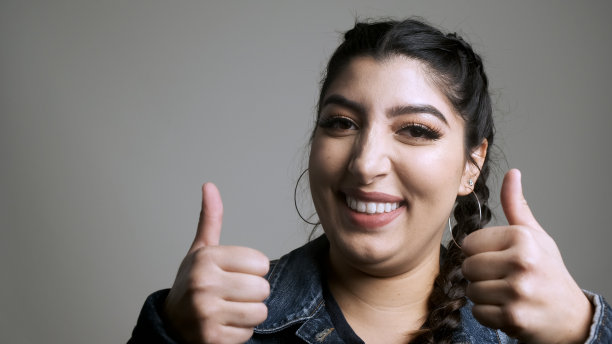 美丽微笑的年轻女子看着镜头图片下载