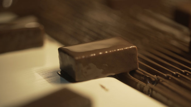 巧克力糖果被送到传送带上。糖果在传送带上。巧克力糖果在传送带上移动。糖果上面覆盖着巧克力图片下载