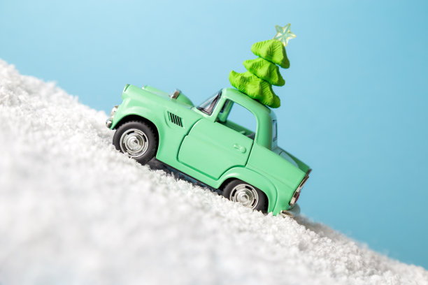 侧视图的小型汽车与圣诞节的节日设备驾驶通过雪抽象。图片下载