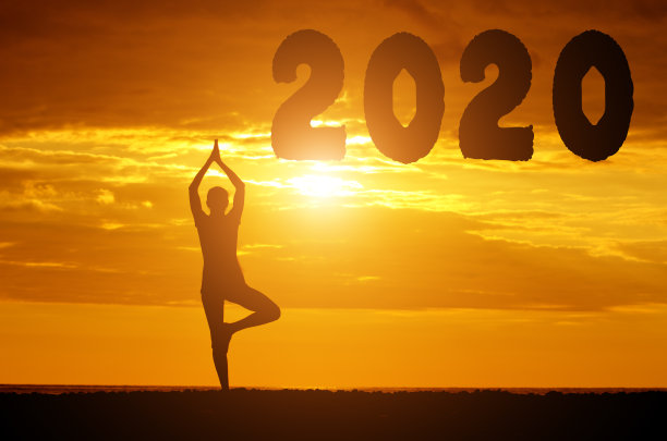 夕阳下的天空中，数字2020的剪影和一个做瑜伽的女孩。新年的概念图片下载