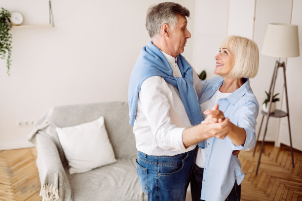 幸福的退休生活的时刻。大四情侣在家跳舞图片下载