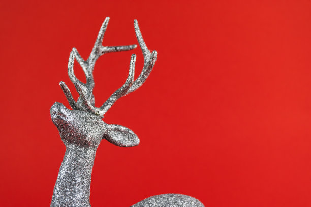 图片描绘了一个银色的闪闪发光的驯鹿造型装饰品的颈部、头部和鹿角。图片下载