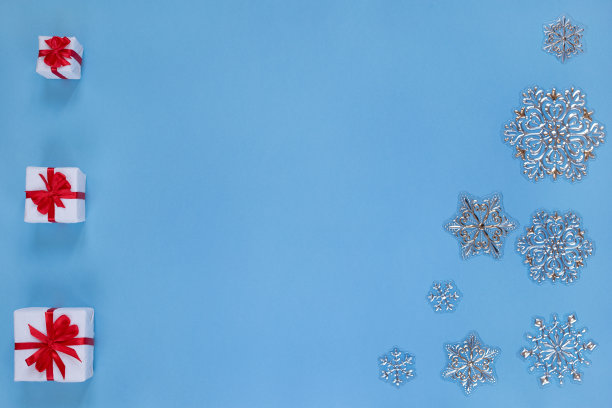 圣诞礼物与丝带和雪花孤立在蓝色的背景。圣诞节和新年的概念。图片下载
