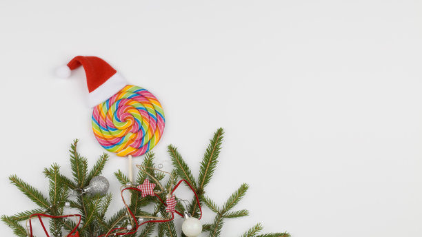 彩色的棒棒糖和冷杉树枝在白色的背景。节日的概念。图片下载