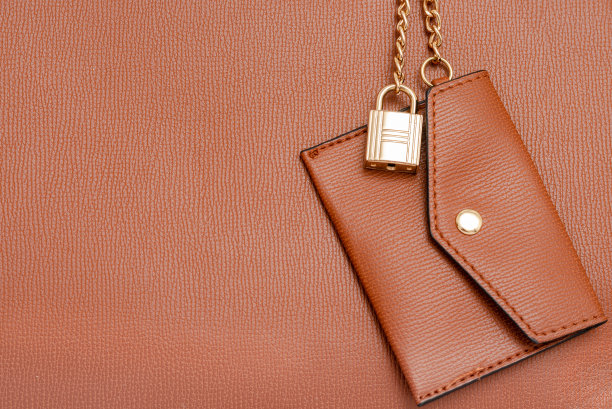 棕色的女性皮夹挂在手提包上。时尚配件。图片下载