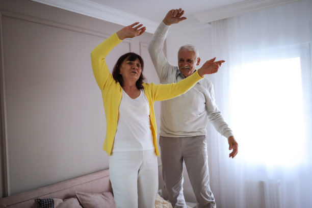 欢快的老年夫妇在床上跳图片下载