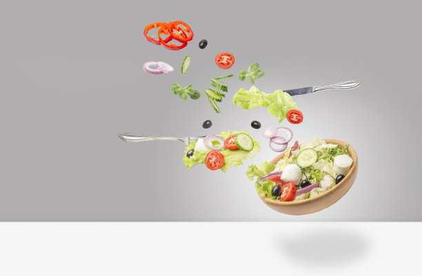 沙拉落在盘子里，孤立在白色的背景上。图片下载