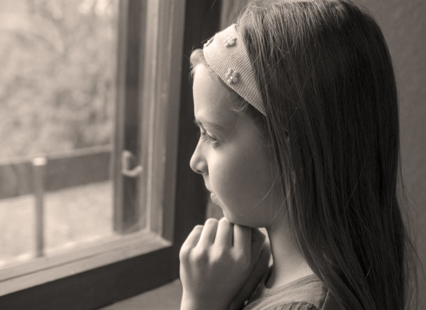 青春期沉思的小女孩望着窗外。黑白图像图片下载