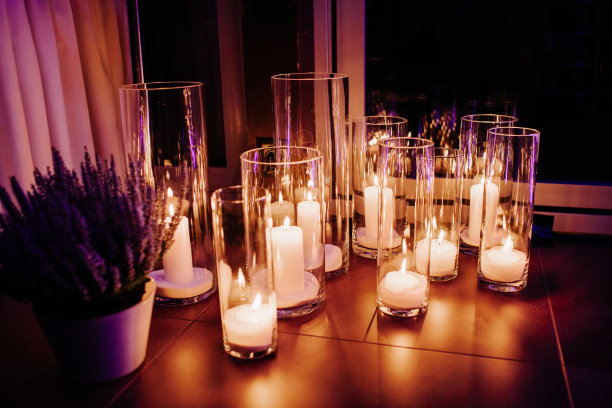 玻璃上装饰着白色燃烧的蜡烛。晚上装饰。图片下载