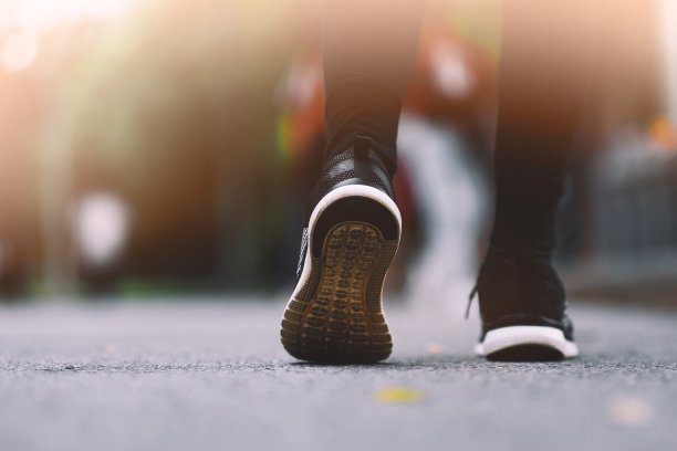 这个女孩穿着黑色的跑鞋在公园里跑步。图片下载