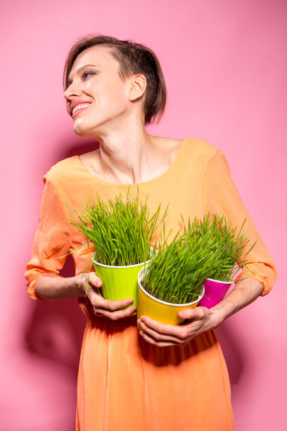 年轻的女士，花盆里装着麦草图片下载