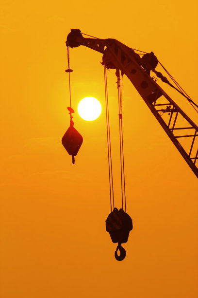 剪影起重机在建筑工地的日落背景。图片下载