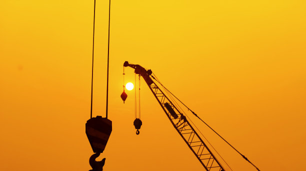 剪影起重机在建筑工地的日落背景。图片下载