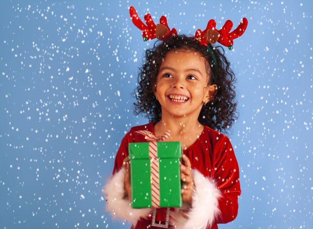非裔美国小女孩拿着一个大圣诞礼盒图片下载
