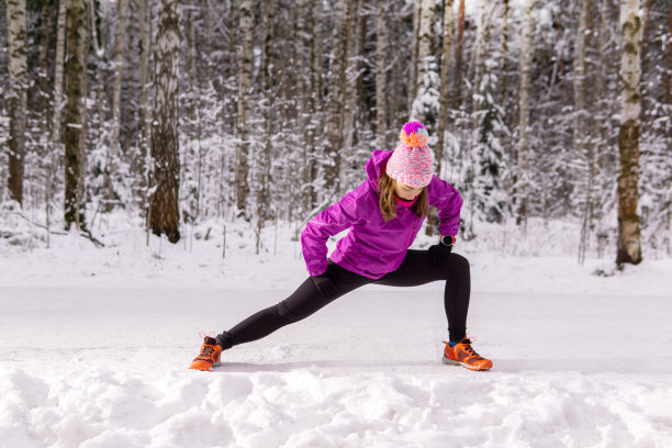 年轻女子在冬季公园慢跑前热身图片下载