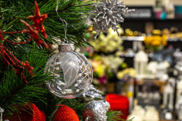 透明银色闪亮的球在圣诞树的背景下，散焦货架在商店。概念圣诞假期大甩卖超市新年图片下载