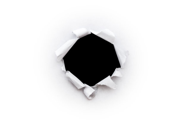 在白纸上的一个圆洞，其边缘被撕裂，孤立在白色背景上，里面是一个孤立的黑色背景。图片下载