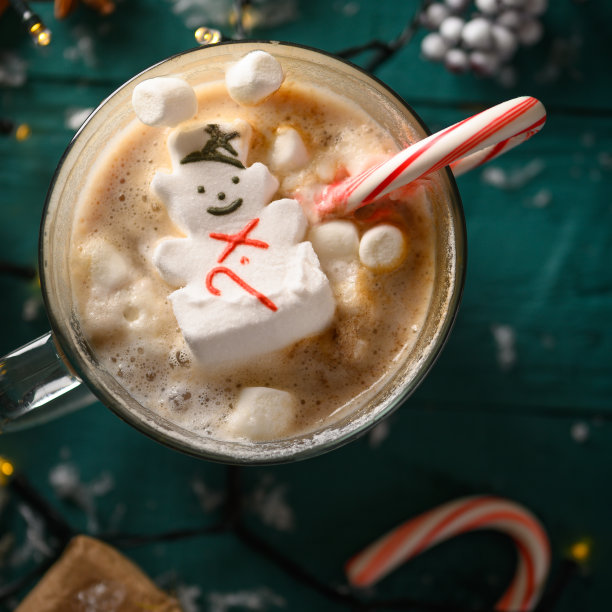圣诞礼物，一杯热巧克力和融化的雪人棉花糖和焦糖。instagram上的Square照片图片下载
