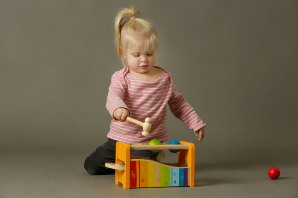 一个蹒跚学步的孩子在玩木琴。木琴有利于学习协调，感官发展，和快乐的孩子，也提供了一个熟悉的基础音乐在这样一个自发和简单的方式。图片下载