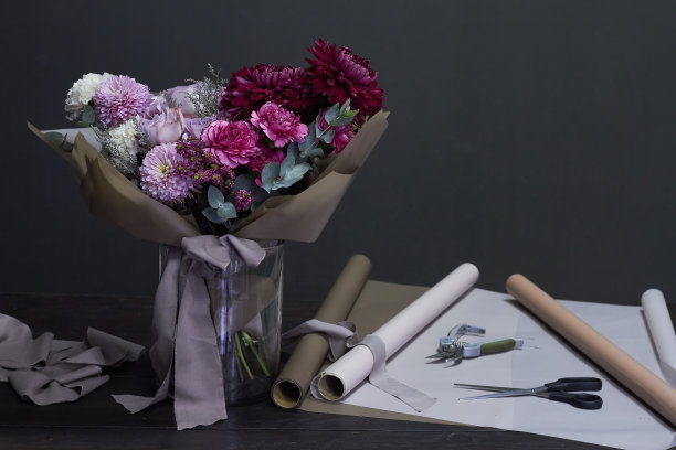 花商的桌面和紫色的复古风格的花束在一个黑暗的背景，选择性的焦点图片下载