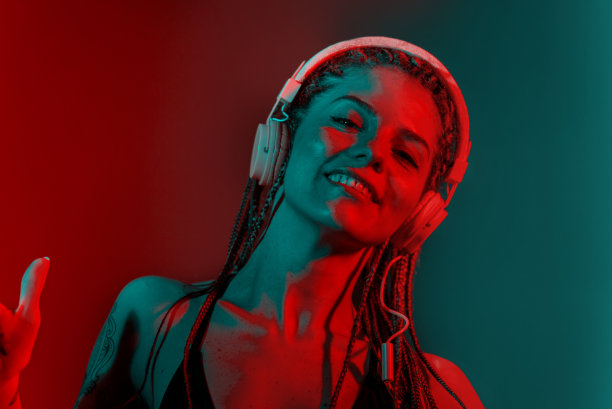 梳着树辫，戴着耳机跳舞的女Dj。图片下载