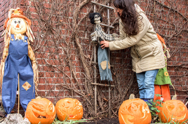 万圣节女人用雕刻的南瓜装饰家图片下载