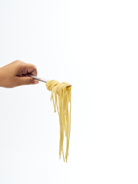 手握意大利面条卷与叉子孤立在一个白色的背景图片下载