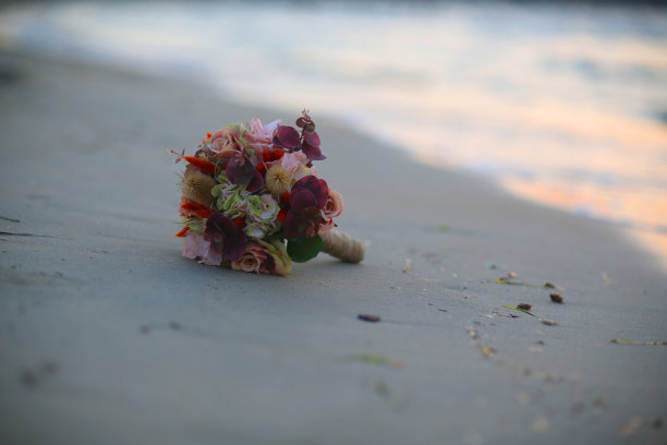 日落时海滩上的新娘花束图片下载