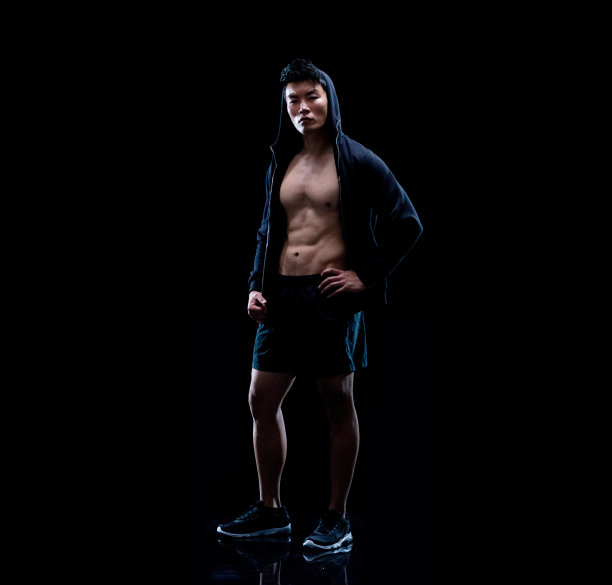 一个男人/一个人/全长30-39岁的成年人英俊的人黑头发中国民族/东亚民族青年男子/男性站在黑色背景/黑色颜色/背光图片下载