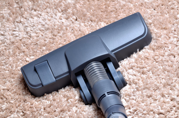 毛绒绒地毯上的吸尘器头-喷嘴的特写图片下载
